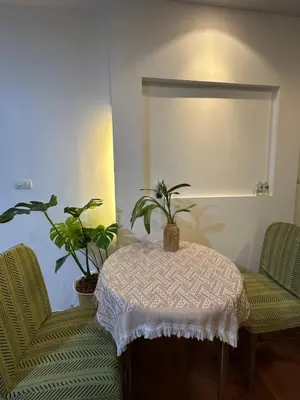 a room with two chairs and a table with two plants at Cozy Condo with full kitchen Patong in Patong Beach