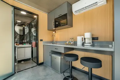 a kitchen with a counter and stools in a room at Apple House Bangtao Pool, Terrace & Breakfast in Ban Lum Fuang