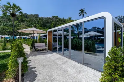 a glass house with a chair and an umbrella at Apple House Seaside Escape with Pool & Breakfast in Ban Lum Fuang