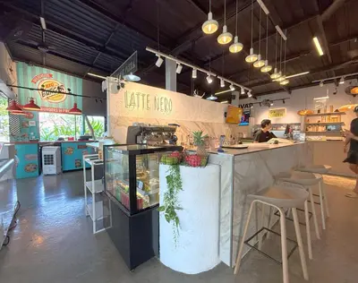 a restaurant with a counter and chairs in a room at Apple House by the Sea, Bangtao Area in Ban Lum Fuang