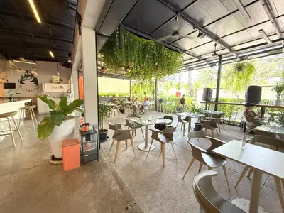 a restaurant with tables and chairs and people in the background at Apple House by the Sea, Bangtao Area in Ban Lum Fuang