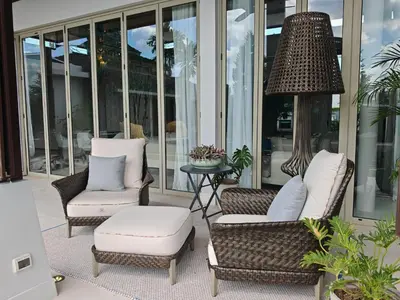 a porch with chairs and a table and a lamp at Luxury Botanica Villa in Ban Phru Champa