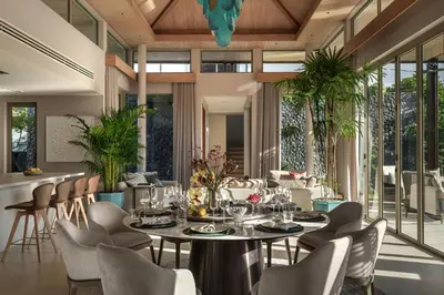 a dining room with a table and chairs at Luxury Botanica Villa in Ban Phru Champa