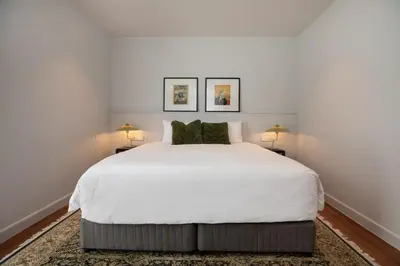 a bedroom with a large white bed with two lamps at Peaceful Penthouse @ Lotus Gardens Layan Beach in Layan Beach