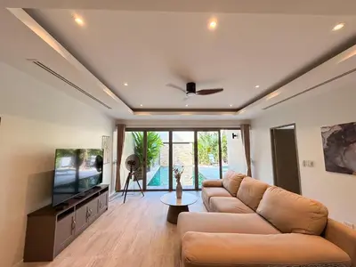 a living room with a couch and a flat screen tv at The Residence Resort Pool Villa 2 Bedrooms and 2 Bathrooms in Ban Thalat Choeng Thale