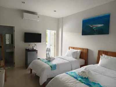 a hotel room with two beds and a flat screen tv at Airport Stay Phuket Zz in Nai Yang Beach