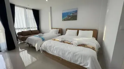 a bedroom with two beds and a couch at Airport Stay Phuket Zz in Nai Yang Beach