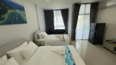 a hotel room with two beds and a television at Airport Stay Phuket Zz in Nai Yang Beach