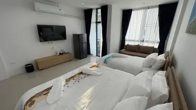 a living room with two beds and a television at Airport Stay Phuket Zz in Nai Yang Beach