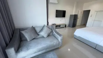 a living room with a couch and a bed at Airport Stay Phuket Zz in Nai Yang Beach