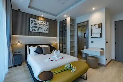 a bedroom with a large white bed and a bathroom at Dara Villas - Rawai in Rawai Beach