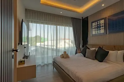 a bedroom with a large bed and a large window at Dara Villas - Rawai in Rawai Beach