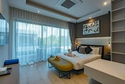 a bedroom with a bed and a large window at Dara Villas - Rawai in Rawai Beach