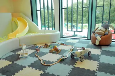 a teddy bear sitting in a chair in a room with a toy train at The Title Legendary by TVC company in Bang Tao Beach