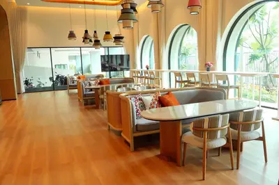 a dining room with tables and chairs and windows at The Title Legendary by TVC company in Bang Tao Beach