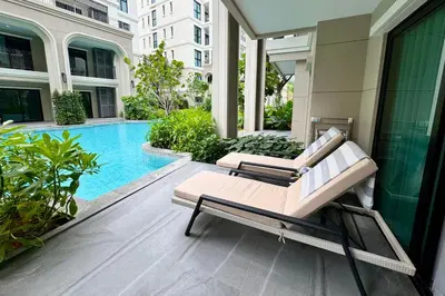 a patio with two lounge chairs and a swimming pool at The Title Legendary by TVC company in Bang Tao Beach