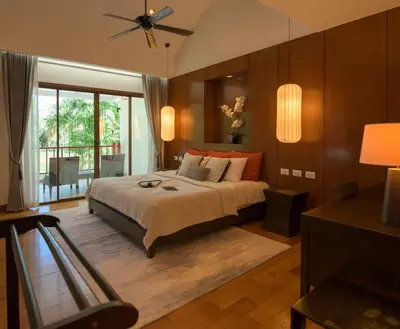 a bedroom with a bed with a ceiling fan at Bursuai - Lake view family pool Laguna Village in Ban Thalat Choeng Thale