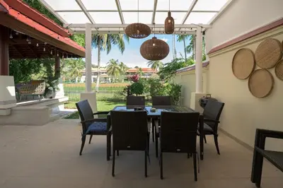 a dining table and chairs on a patio at Bursuai - Lake view family pool Laguna Village in Ban Thalat Choeng Thale