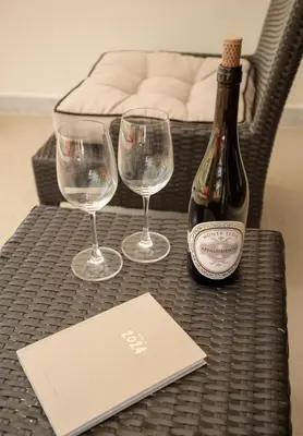 a bottle of wine and two wine glasses on a table at Bursuai - Lake view family pool Laguna Village in Ban Thalat Choeng Thale