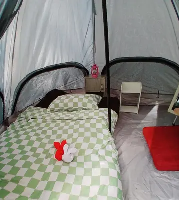a bed in a tent with a red flower on it at Kalaland Patong camp in Patong Beach