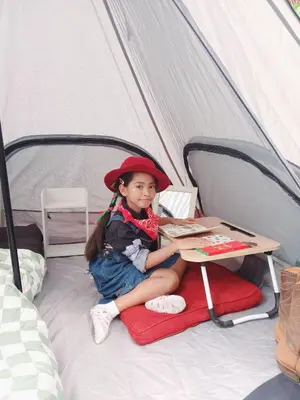 a little girl sitting on a bed in a tent at Kalaland Patong camp in Patong Beach