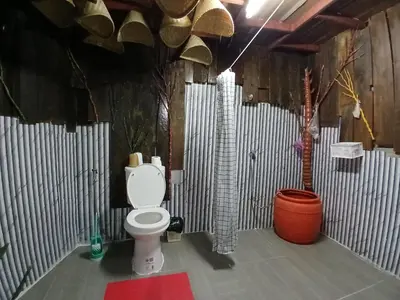 a bathroom with a toilet and a tree in it at Kalaland Patong camp in Patong Beach