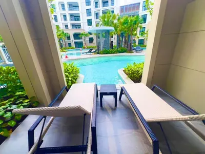 a balcony with two chairs and a swimming pool at title legendary in Bang Tao Beach
