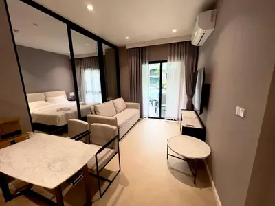 a hotel room with a bed and a table and chairs at title legendary in Bang Tao Beach