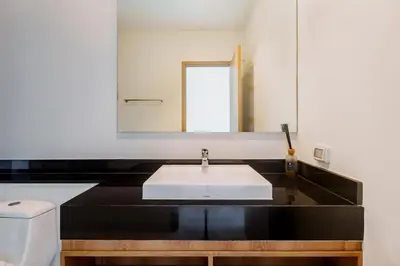 a bathroom with a white sink and a mirror at Niva Villa - Modern & Lake View near Phuket town in Ban Bang Khu