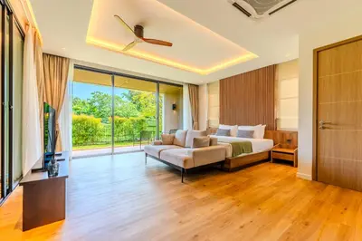 a bedroom with a bed and a couch and a television at Niva Villa - Modern & Lake View near Phuket town in Ban Bang Khu