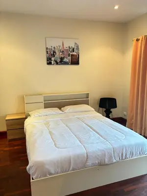 a bed in a bedroom with a picture on the wall at NS Private Pool villa in Ban Na Kok