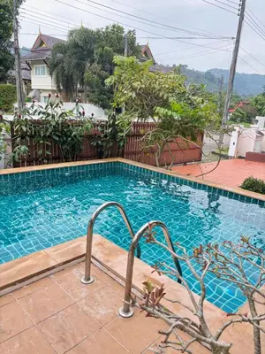 a swimming pool with blue water in front of a house at NS Private Pool villa in Ban Na Kok