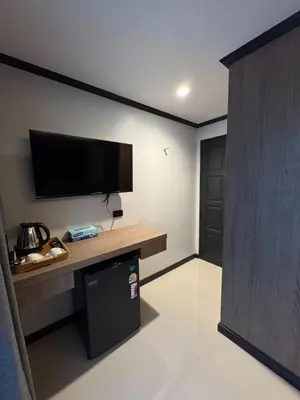 a room with a tv on a wall with a desk at Black Pantera House in Patong Beach