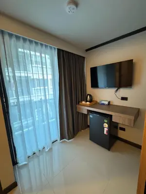 a hotel room with a desk and a television at Black Pantera House in Patong Beach