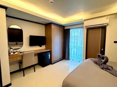 a hotel room with a bed and a desk and a television at Black Pantera House in Patong Beach