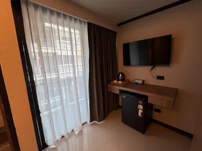 a hotel room with a large window with a flat screen tv at Black Pantera House in Patong Beach