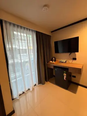 a hotel room with a desk and a large window at Black Pantera House in Patong Beach