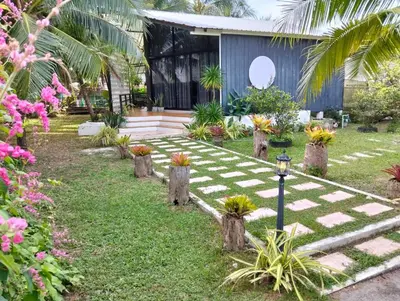 a garden with a checkered path in front of a building at Parin House Homestay - Koh Yao Noi in Ko Yao Noi