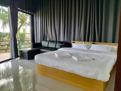 a bedroom with a large bed and a couch at Parin House Homestay - Koh Yao Noi in Ko Yao Noi