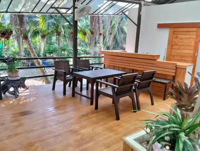 a patio with a table and chairs and a bench at Parin House Homestay - Koh Yao Noi in Ko Yao Noi