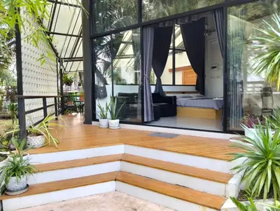 a house with glass walls and a wooden floor at Parin House Homestay - Koh Yao Noi in Ko Yao Noi