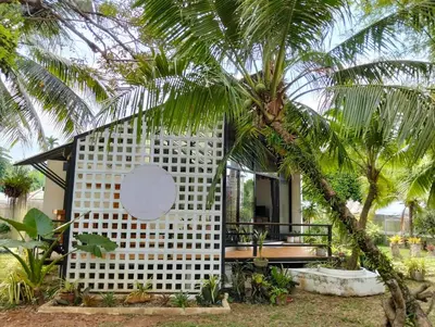 a modern house with a white facade and a palm tree at Parin House Homestay - Koh Yao Noi in Ko Yao Noi