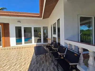 a porch with chairs and a patio with a pool at B&K private pool Villa in Rawai Beach
