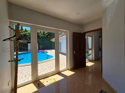 a room with a view of a swimming pool through windows at B&K private pool Villa in Rawai Beach