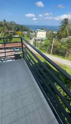 a bench on a balcony with a view of the ocean at Patong View by Thainish Res - Accommodation for Rentals in Ban Na Nai
