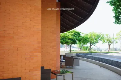 a brick wall with a bench next to a building at Suite With Sea View By Mida Grande Resort in Ban Lum Fuang