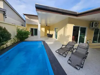 a swimming pool with two chairs and a house at Rawai 4 Bedrooms Private Pool Villa in Rawai Beach
