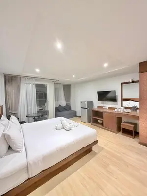 a bedroom with a large white bed and a television at One Houses in Patong Beach