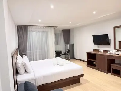 a hotel room with a bed and a flat screen tv at One Houses in Patong Beach