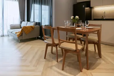 a living room with a table and chairs with wine glasses at Brand New 2-BR apartment, only 7 min to the beach! in Bang Tao Beach